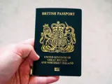 Hand holding a new style blue British passport