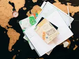 Passport visa stamps and compass on world map